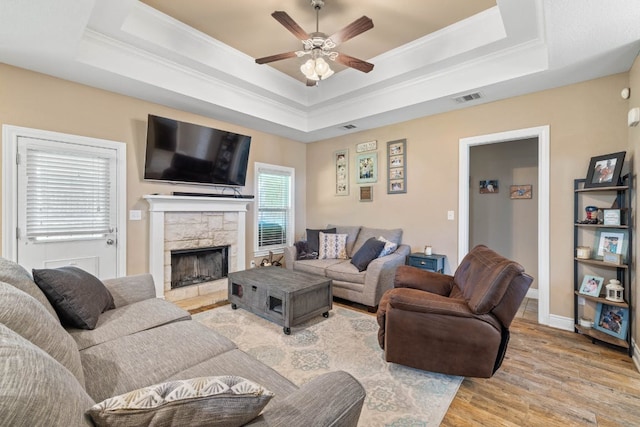 198 Sheridan Loop, Belton, TX 76513 - living area with ceiling fan, a tray ceiling, light wood-style flooring, a fireplace, and crown molding