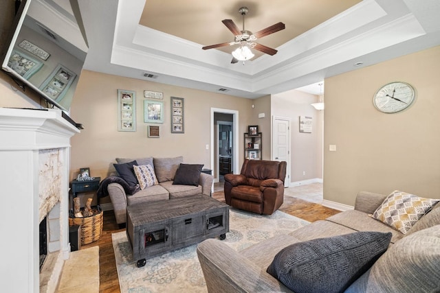 198 Sheridan Loop, Belton, TX 76513 - living room with a high end fireplace, a ceiling fan, a raised ceiling, and crown molding