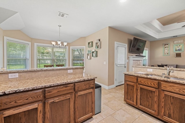 198 Sheridan Loop, Belton, TX 76513 - kitchen featuring healthy amount of natural light, tasteful backsplash, brown cabinetry, and vaulted ceiling