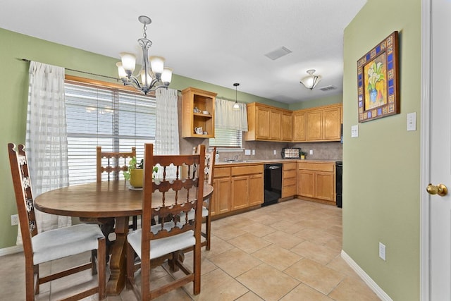 2127 Redwing Way, Round Rock, TX 78664 - kitchen featuring black dishwasher, a chandelier, tasteful backsplash, light countertops, and hanging light fixtures