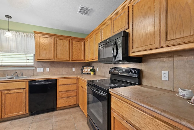 2127 Redwing Way, Round Rock, TX 78664 - kitchen with black appliances, decorative backsplash, light tile patterned floors, and light countertops