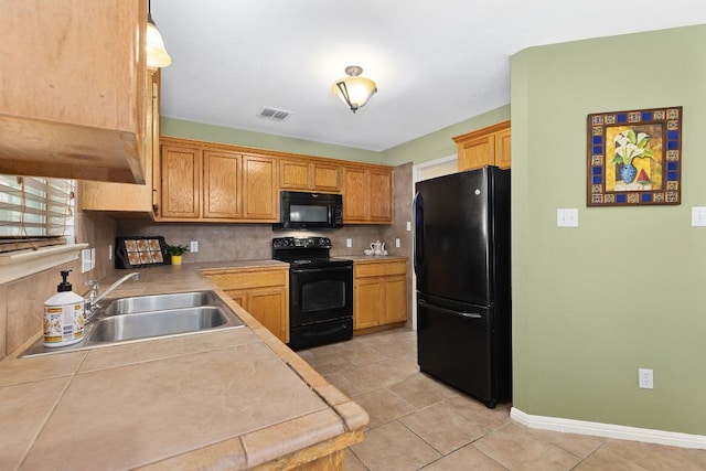 2127 Redwing Way, Round Rock, TX 78664 - kitchen with black appliances, tasteful backsplash, light countertops, and light tile patterned flooring