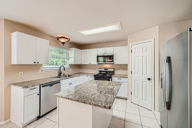 17714 Limpia Crk, Round Rock, TX 78664 - kitchen with stainless steel appliances, white cabinets, a kitchen island, light stone countertops, and light tile patterned flooring
