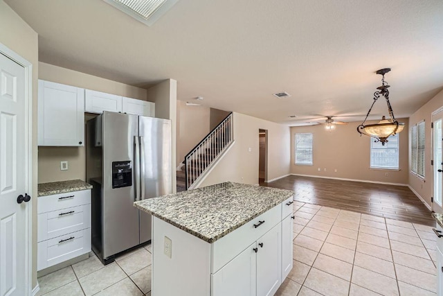 17714 Limpia Crk, Round Rock, TX 78664 - kitchen featuring stainless steel refrigerator with ice dispenser, light tile patterned floors, healthy amount of natural light, and a center island