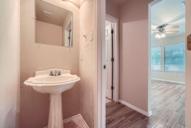 17714 Limpia Crk, Round Rock, TX 78664 - bathroom featuring a textured wall, a ceiling fan, and wood tiled floors