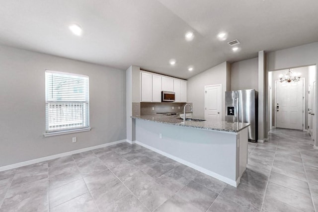 12301 Amber Lynn Path, Manor, TX 78653 - kitchen featuring appliances with stainless steel finishes, light stone countertops, a peninsula, white cabinets, and a chandelier
