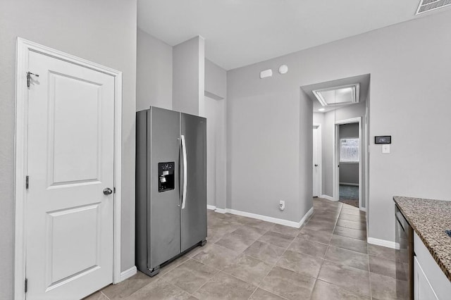12301 Amber Lynn Path, Manor, TX 78653 - kitchen with stainless steel fridge, light stone countertops, light tile patterned floors, and white cabinets