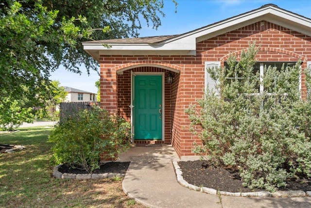 2102 Garrison Dr, Leander, TX 78641 - view of exterior entry featuring brick siding and a yard