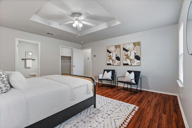 2102 Garrison Dr, Leander, TX 78641 - bedroom with a raised ceiling, wood finished floors, ensuite bath, and ceiling fan