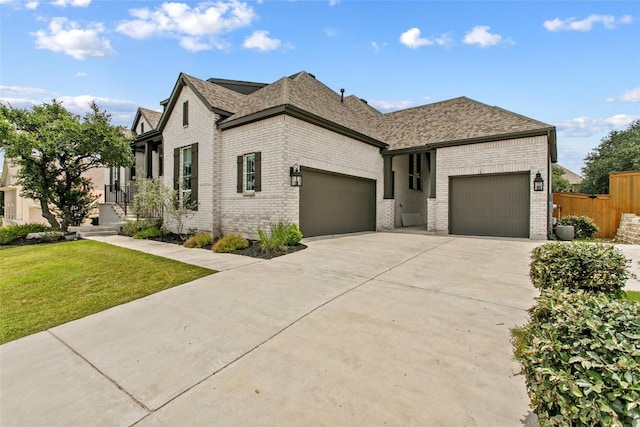237 Honey Bee Ln, Austin, TX 78737 - view of front facade with brick siding, an attached garage, concrete driveway, and a shingled roof