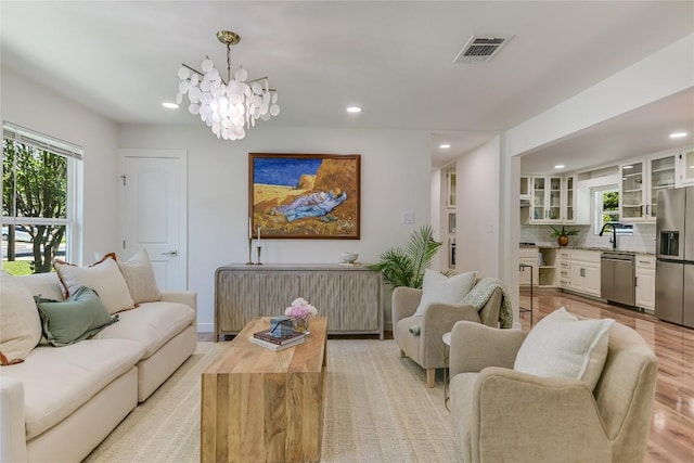 7806 Mullen Dr, Austin, TX 78757 - living room with recessed lighting, healthy amount of natural light, a chandelier, radiator heating unit, and light wood-type flooring