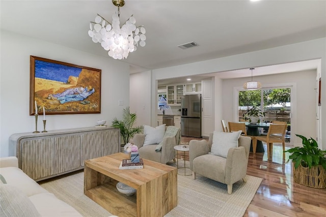 7806 Mullen Dr, Austin, TX 78757 - living area featuring light wood-style flooring, a chandelier, radiator heating unit, and recessed lighting
