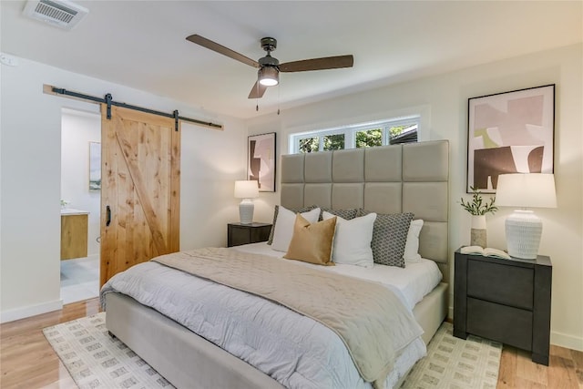7806 Mullen Dr, Austin, TX 78757 - bedroom featuring a barn door, wood finished floors, and ceiling fan