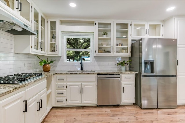 7806 Mullen Dr, Austin, TX 78757 - kitchen with appliances with stainless steel finishes, light stone counters, under cabinet range hood, white cabinets, and decorative backsplash