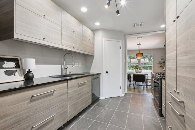 13101 Silver Creek Dr, Austin, TX 78727 - kitchen featuring gas range oven, dishwasher, dark countertops, modern cabinets, and dark tile patterned floors
