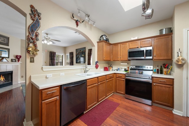18112 Skysail Dr, Manor, TX 78653 - kitchen featuring stainless steel appliances, light countertops, arched walkways, and dark wood-type flooring