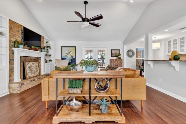 4001 Greystone Dr, Austin, TX 78731 - living area featuring vaulted ceiling, ceiling fan, wood finished floors, built in shelves, and a brick fireplace