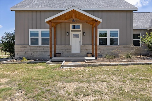 105 Mesa Grande Ct, Marble Falls, TX 78654 - view of front of property featuring a shingled roof, stone siding, a front yard, and board and batten siding