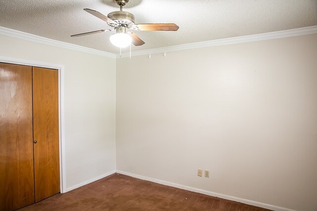 215 Edward Ln, Brenham, TX 77833 - unfurnished bedroom featuring a closet, ornamental molding, a textured ceiling, ceiling fan, and dark carpet