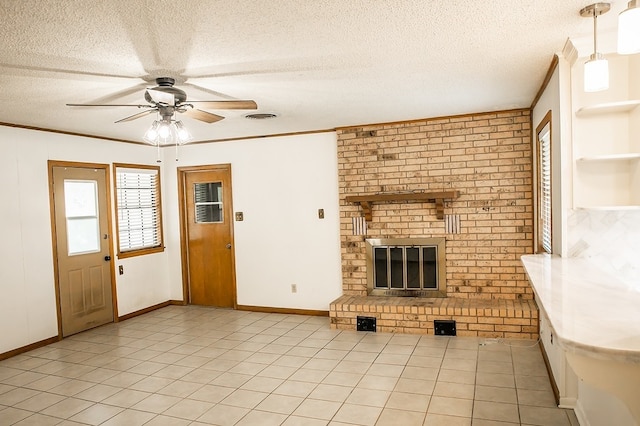 215 Edward Ln, Brenham, TX 77833 - unfurnished living room featuring a ceiling fan, a textured ceiling, crown molding, a fireplace, and light tile patterned floors