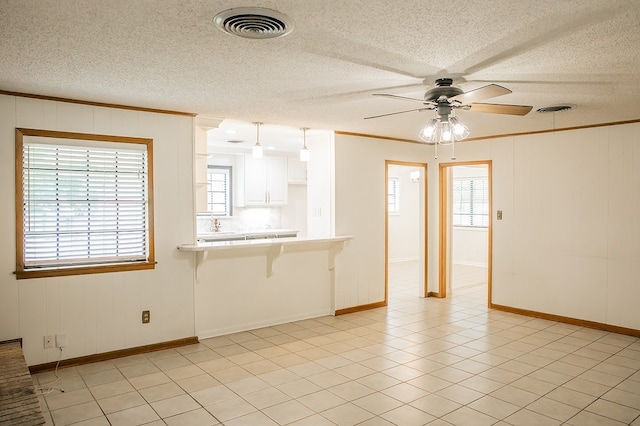 215 Edward Ln, Brenham, TX 77833 - unfurnished living room with plenty of natural light, ceiling fan, ornamental molding, and a textured ceiling