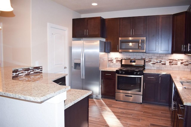 3303 Elija St Unit A & B, Austin, TX 78745 - kitchen with stainless steel appliances, decorative backsplash, light stone countertops, light wood-style flooring, and recessed lighting