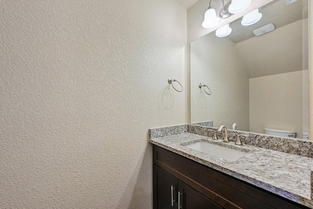 3303 Elija St Unit A & B, Austin, TX 78745 - bathroom featuring vanity, vaulted ceiling, and a textured wall