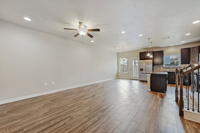 3303 Elija St Unit A & B, Austin, TX 78745 - unfurnished living room featuring wood finished floors, a ceiling fan, recessed lighting, and a textured ceiling
