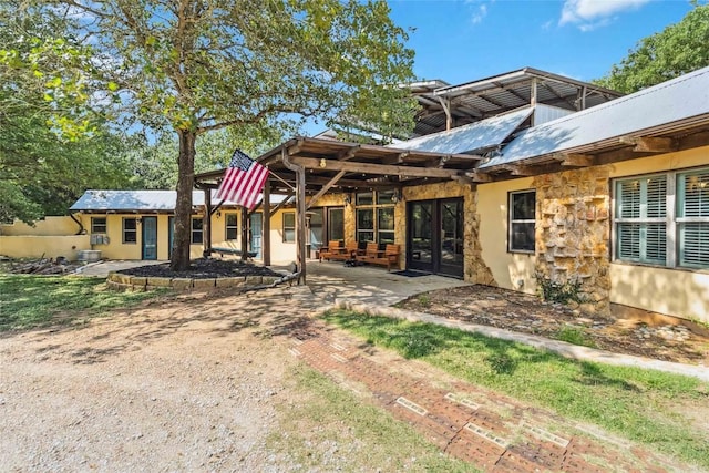 208 Old Potato Rd, Paige, TX 78659 - back of house featuring a patio, stone siding, and stucco siding