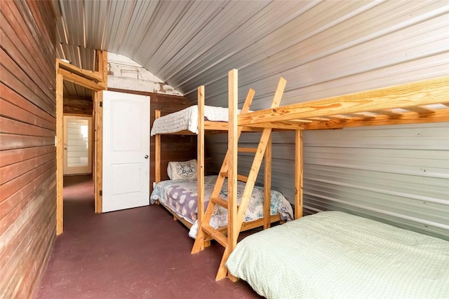 208 Old Potato Rd, Paige, TX 78659 - bedroom featuring wooden walls, concrete flooring, and vaulted ceiling