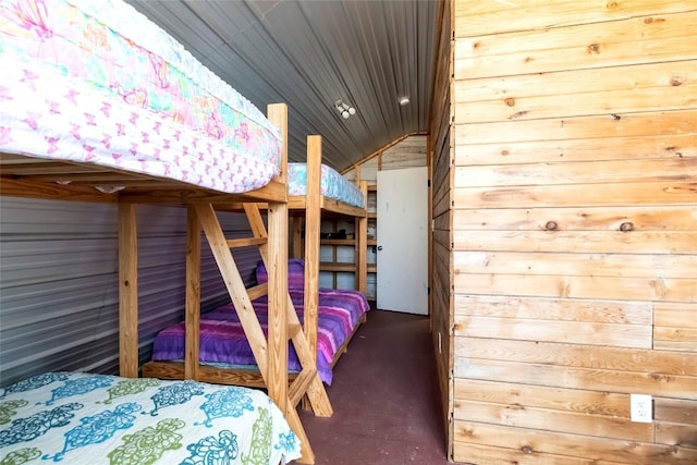 208 Old Potato Rd, Paige, TX 78659 - bedroom with wood walls, finished concrete floors, and vaulted ceiling