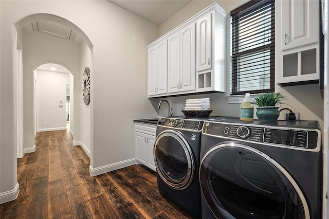 3810 Pawnee Pass, Austin, TX 78738 - laundry area featuring washing machine and clothes dryer, dark wood-style floors, cabinet space, and arched walkways