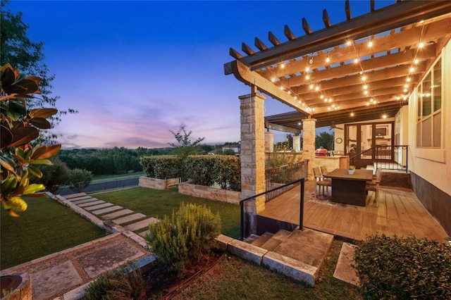 3810 Pawnee Pass, Austin, TX 78738 - yard at dusk featuring a lawn, outdoor dining area, a pergola, and a wooden deck