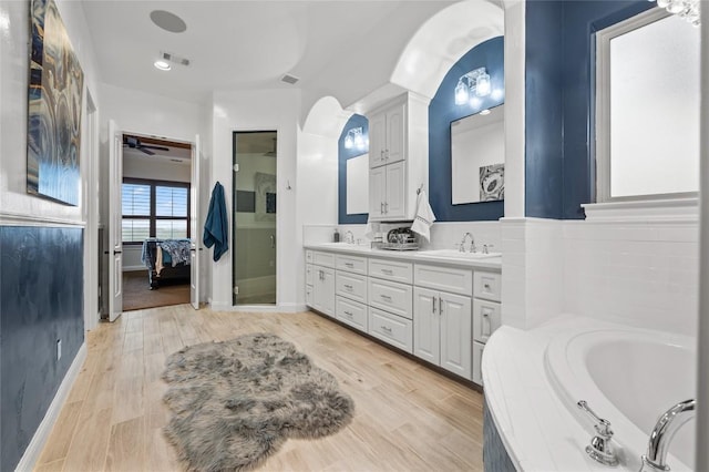 3810 Pawnee Pass, Austin, TX 78738 - ensuite bathroom featuring double vanity, a garden tub, wood finished floors, and ceiling fan