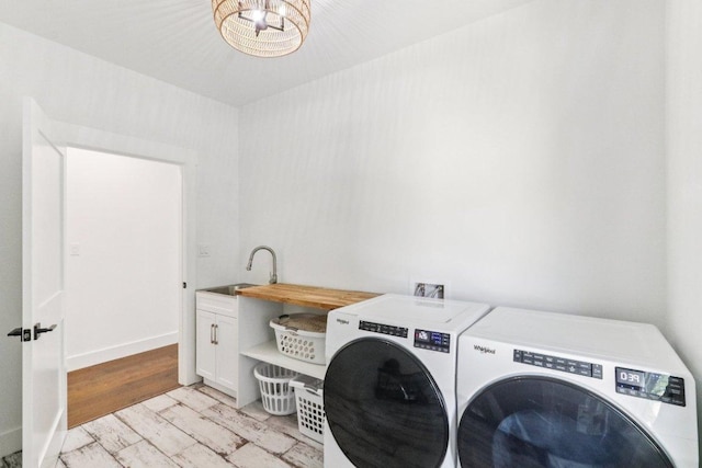169 Tall Forest Dr, Bastrop, TX 78602 - washroom with washing machine and clothes dryer, cabinet space, and a chandelier