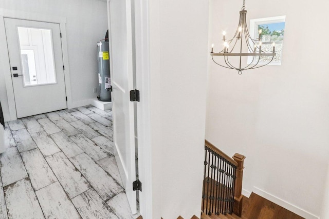 169 Tall Forest Dr, Bastrop, TX 78602 - corridor with a chandelier, wood finished floors, water heater, and an upstairs landing