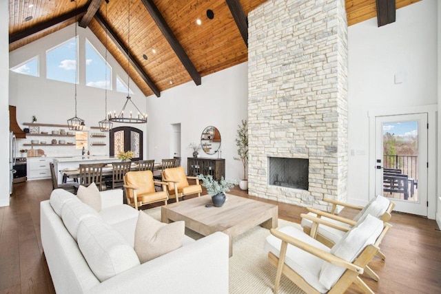 169 Tall Forest Dr, Bastrop, TX 78602 - living area with high vaulted ceiling, a wood ceiling with exposed beams, dark wood-style floors, a fireplace, and a chandelier
