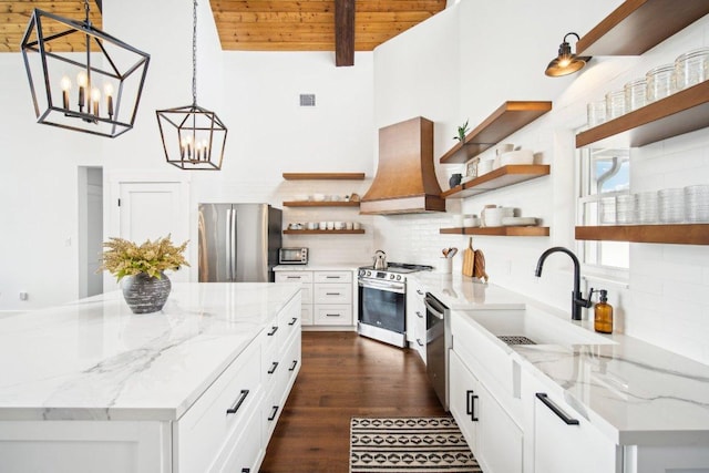 169 Tall Forest Dr, Bastrop, TX 78602 - kitchen with open shelves, appliances with stainless steel finishes, custom range hood, a chandelier, and a wooden ceiling with exposed beams