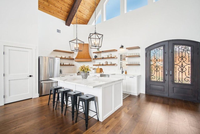 169 Tall Forest Dr, Bastrop, TX 78602 - kitchen featuring freestanding refrigerator, open shelves, high vaulted ceiling, french doors, and custom exhaust hood
