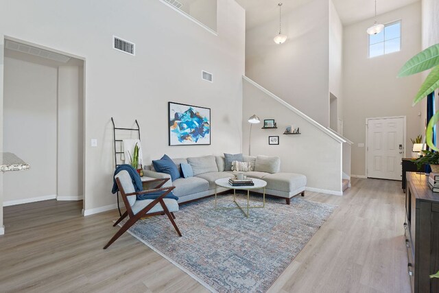 3526 Wickham Ln, Austin, TX 78725 - living area with a towering ceiling, stairway, and light wood-style floors