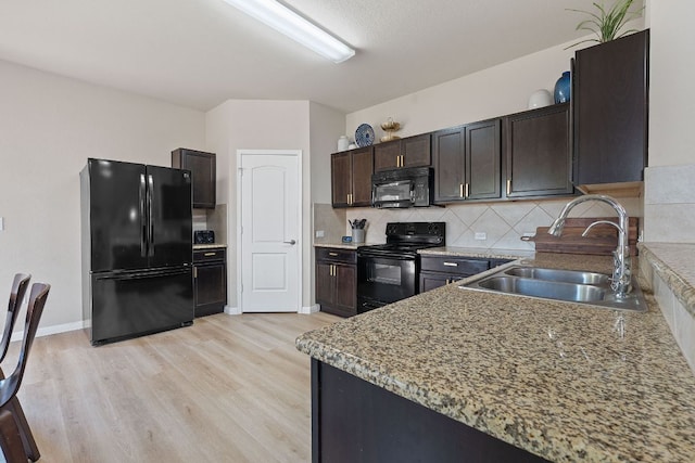 3526 Wickham Ln, Austin, TX 78725 - kitchen with black appliances, light wood-style flooring, decorative backsplash, and dark brown cabinetry