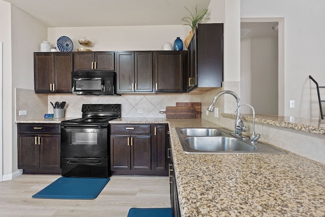 3526 Wickham Ln, Austin, TX 78725 - kitchen featuring black appliances, light wood-style flooring, and backsplash