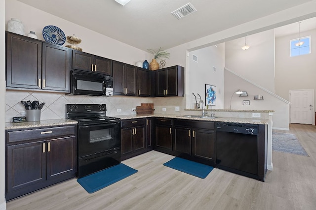 3526 Wickham Ln, Austin, TX 78725 - kitchen featuring black appliances, light wood finished floors, a peninsula, and tasteful backsplash