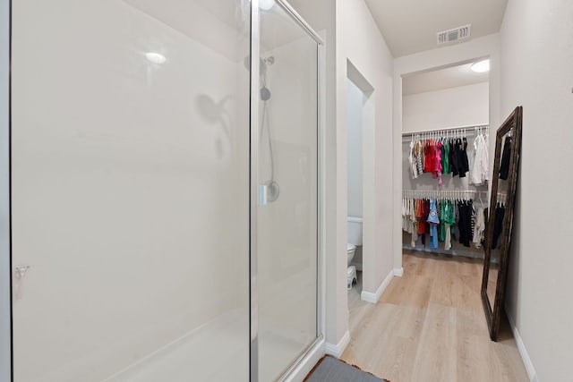 3526 Wickham Ln, Austin, TX 78725 - full bathroom featuring wood finished floors, a stall shower, and a spacious closet