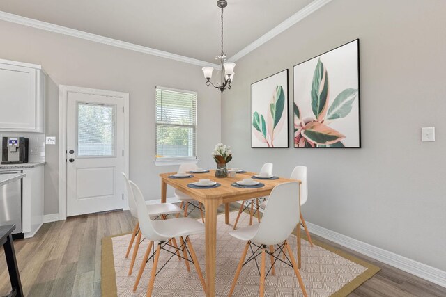 103 W Tomlinson St, Florence, TX 76527 - dining space with crown molding, light wood-type flooring, and a chandelier