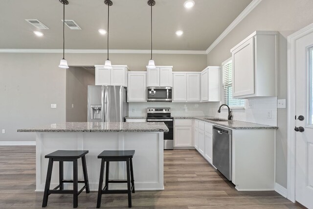 103 W Tomlinson St, Florence, TX 76527 - kitchen with stainless steel appliances, a center island, tasteful backsplash, light stone countertops, and crown molding