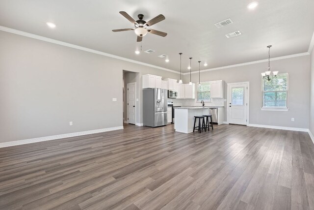 103 W Tomlinson St, Florence, TX 76527 - living area featuring ceiling fan, a chandelier, dark wood-type flooring, ornamental molding, and recessed lighting