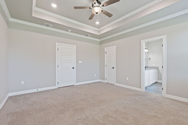 103 W Tomlinson St, Florence, TX 76527 - unfurnished bedroom with carpet floors, ornamental molding, a tray ceiling, recessed lighting, and connected bathroom