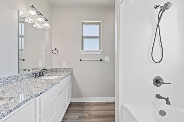 103 W Tomlinson St, Florence, TX 76527 - bathroom with double vanity, shower / washtub combination, and wood finished floors