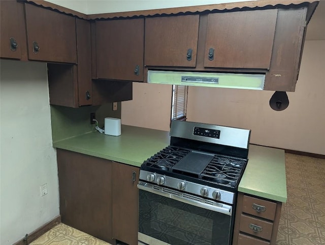606 Scurry St, Austin, TX 78753 - kitchen with stainless steel gas range, light countertops, dark brown cabinets, and ventilation hood